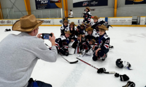 Hockey dad taking a team photo with youth hockey players at the Showdown Tournament in Nashville, TN